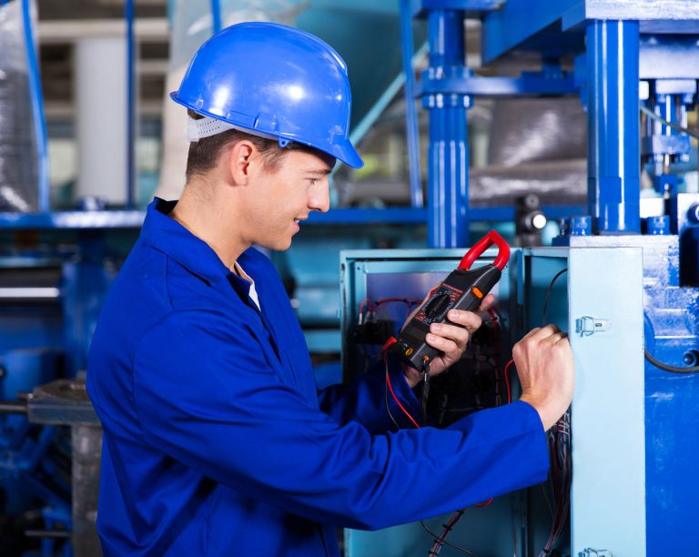 32755247 - industrial technician examining control box with digital insulation tester